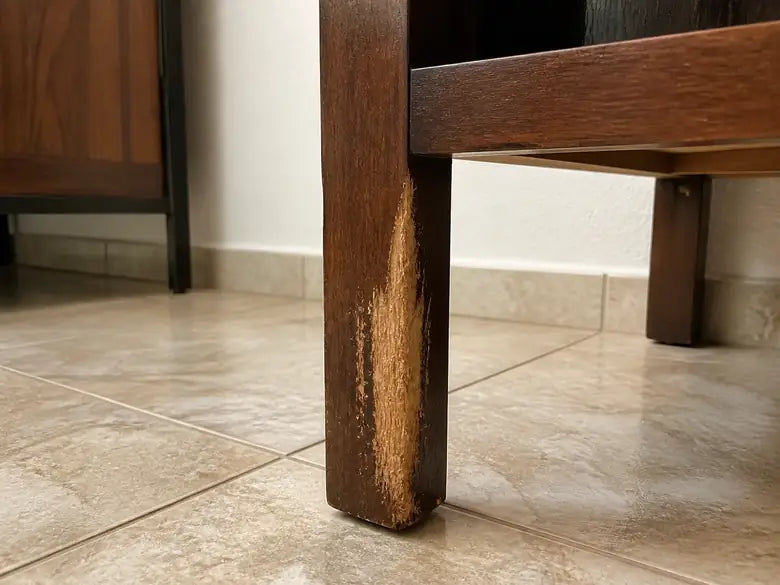Pata de mueble de madera con marcas de mordida