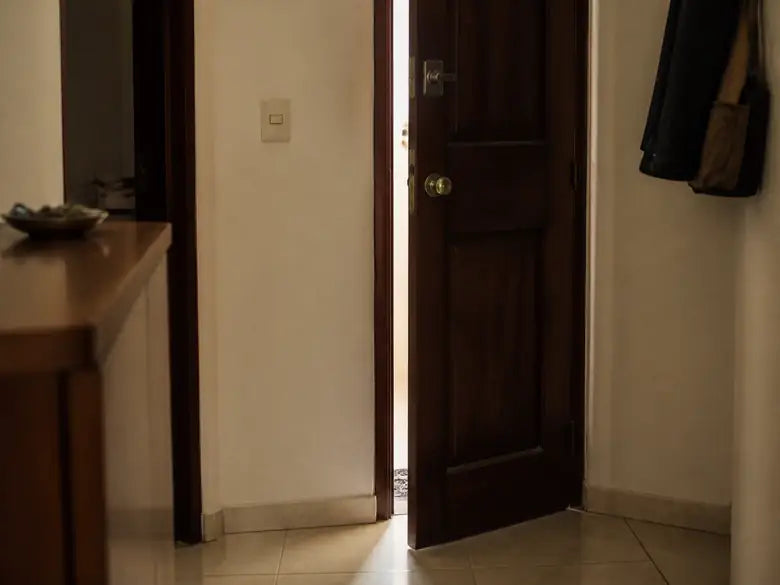 Puerta de apartamento entreabierta vista desde adentro